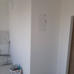 Malarz Krzych Krzysztof Kaźmierczak - Świeżo pomalowane, białe ściany wewnętrzne z ukrytą szafką rewizyjną i fragmentem marmurowej ściany oraz mopem w rogu