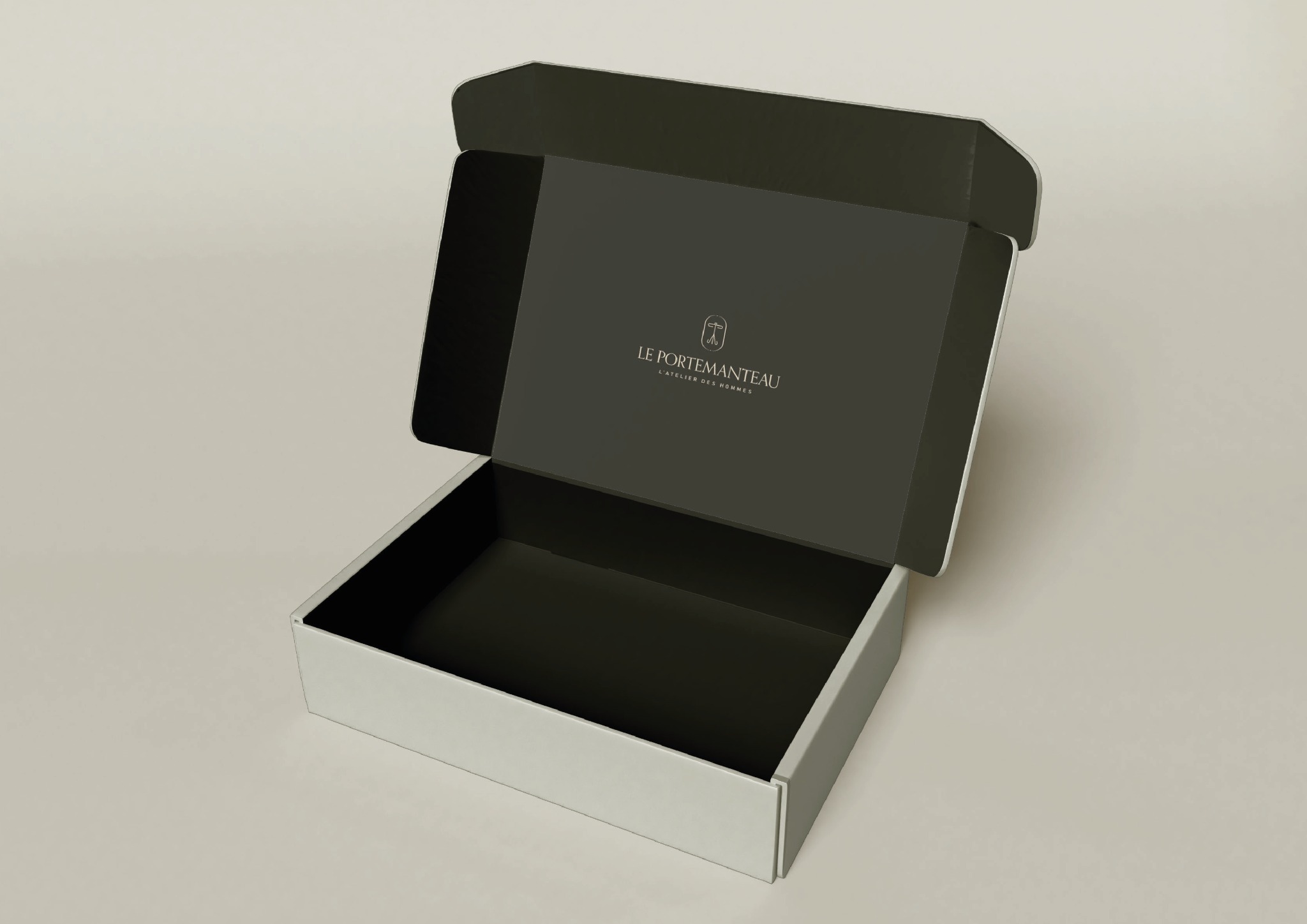 Otwarty, minimalistyczny karton w kolorze ecru z ciemnoszarym wnętrzem, na którym widnieje logo 'Le Portemanteau', prezentowany z perspektywy.