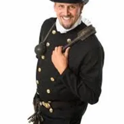 Uśmiechnięty mężczyzna w tradycyjnym stroju kominiarskim z cylindrem, trzymający szczotkę kominiarską na ramieniu, na białym tle.