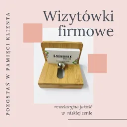 Stojak bambusowy z wizytówkami firmy Boomdruk, metalowa kulka przytrzymująca karty, pastelowe tło z tekstem reklamowym.