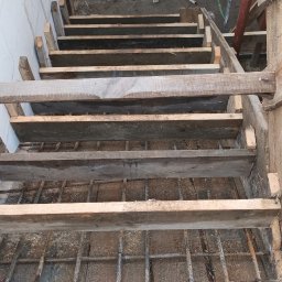 BDP Polska Daniel Budek - Konstrukcja drewniana szalunku schodów z widocznym zbrojeniem, przygotowana do zalania betonem, widok z góry na placu budowy.