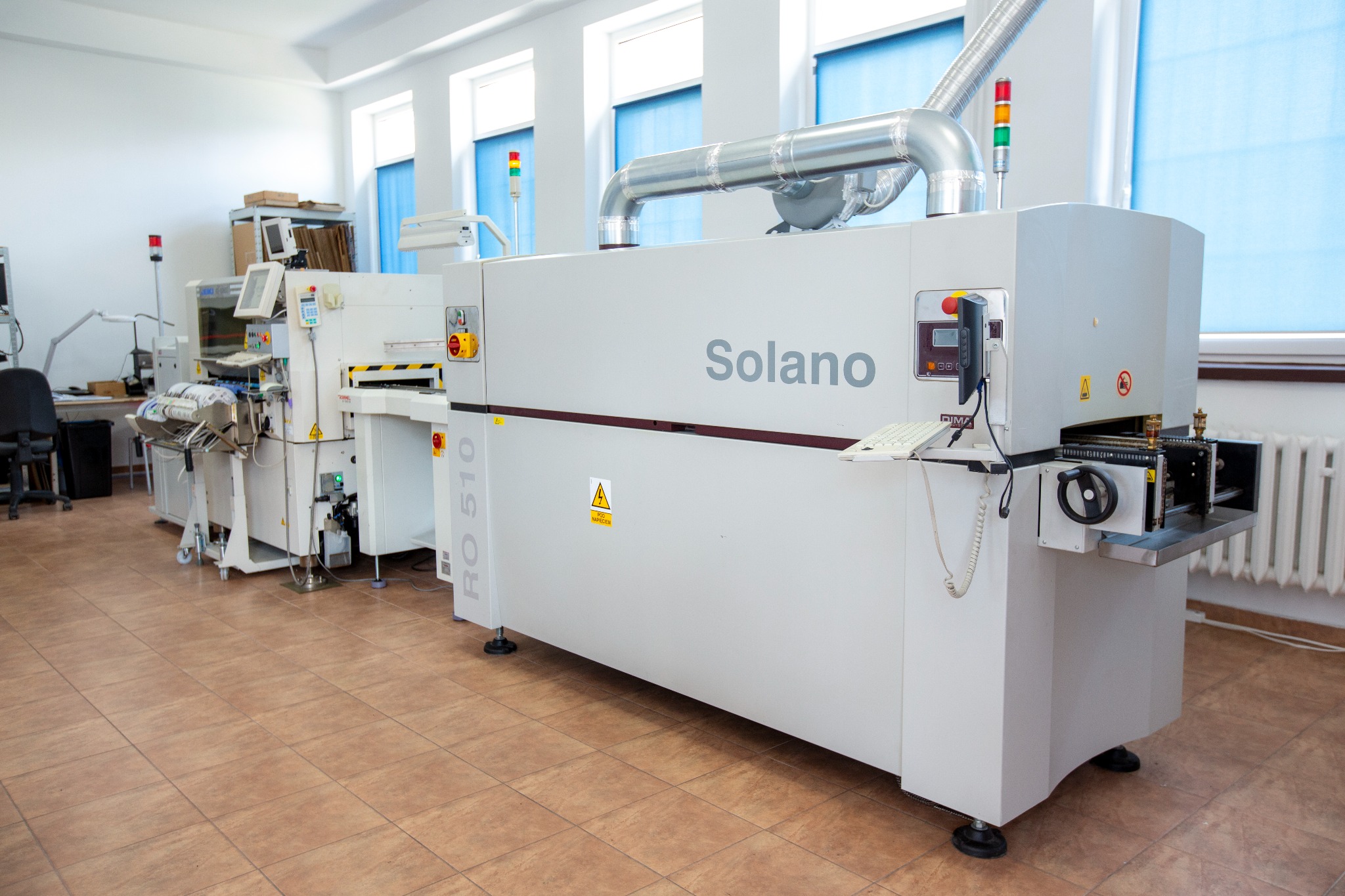 Linia produkcyjna Solano RO 510 w jasnym pomieszczeniu z oknami, widoczne elementy sterujące i system odprowadzania oparów.