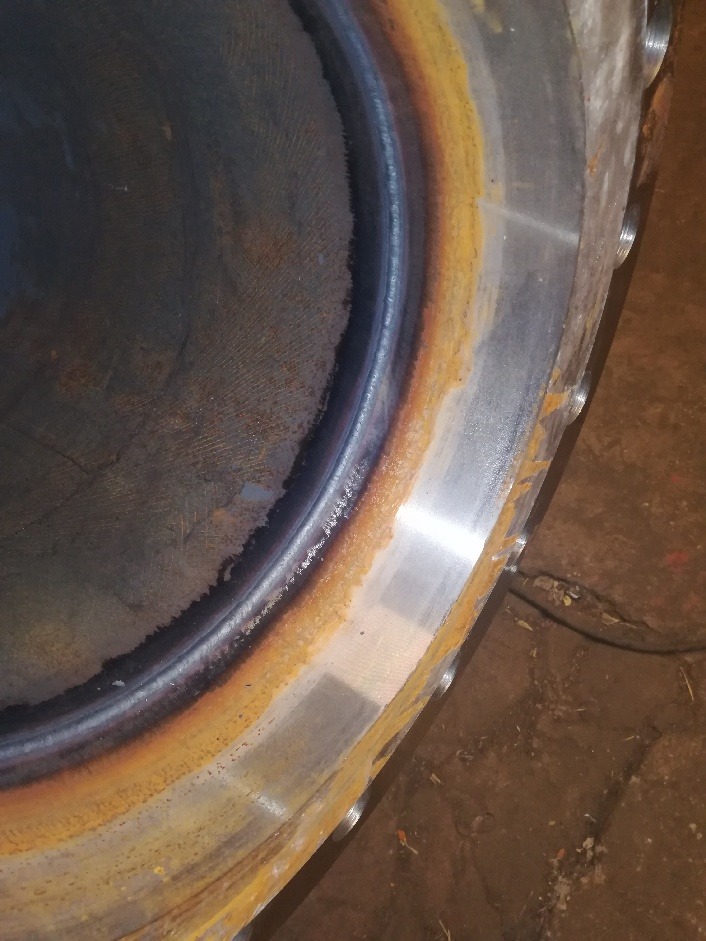 Spoina obwodowa na grubościennej, stalowej rurze z widocznymi śladami korozji i obróbki powierzchniowej