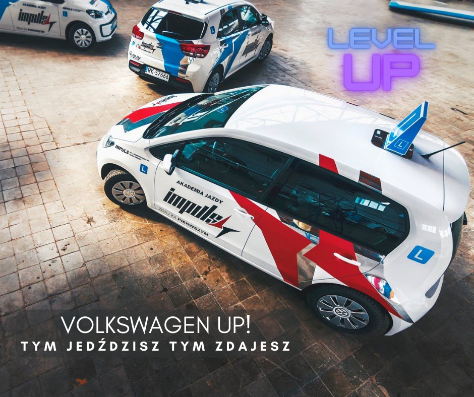 Volkswagen UP w barwach ośrodka szkolenia kierowców z charakterystyczną literą 'L' na dachu, widziany z góry, zaparkowany na betonowym placu wraz z innymi pojazdami ośrodka.