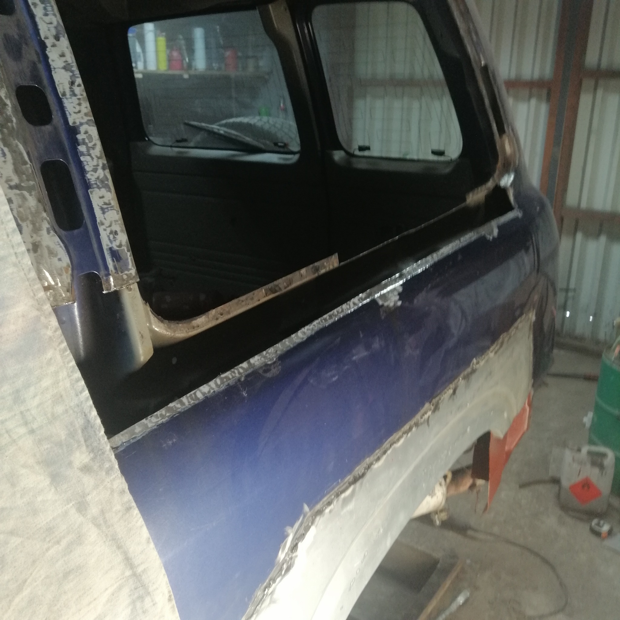 Fragment karoserii w trakcie naprawy blacharskiej w Pszczółkach. Widoczne łączenia blach i elementy konstrukcyjne pojazdu. Prace spawalnicze w toku.