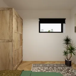 Wnętrze sypialni z drewnianą szafą o zdobionych drzwiach, dywanem w orientalny wzór i rośliną doniczkową przy oknie z roletą.