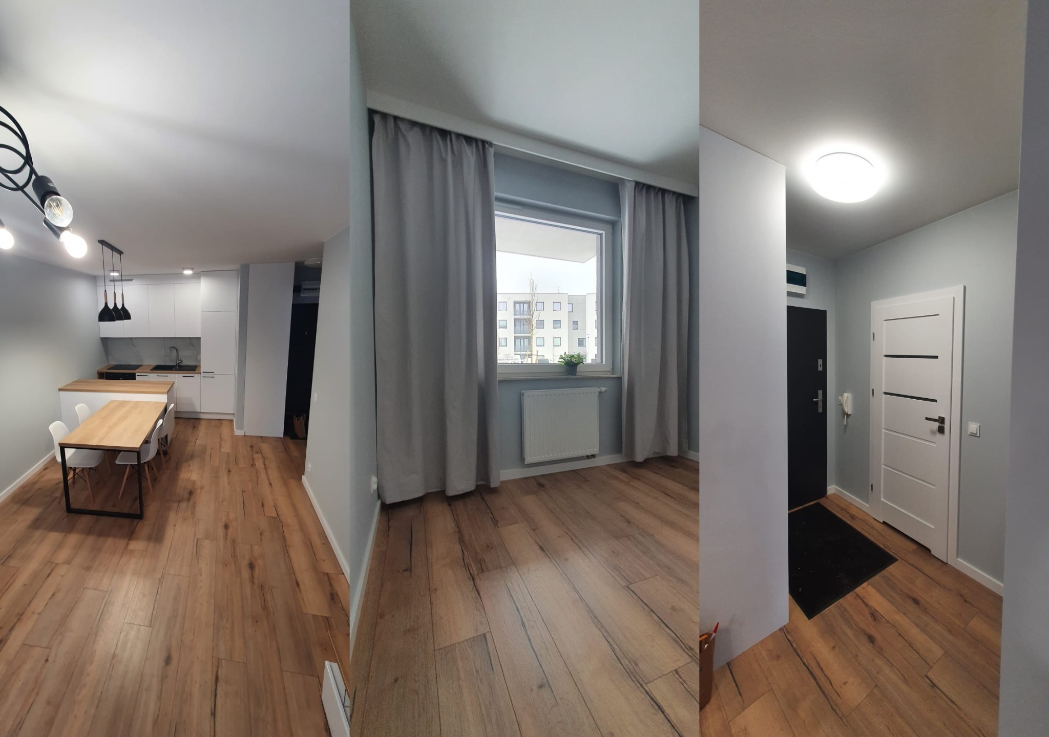 Salon z aneksem kuchennym i przedpokojem po remoncie: drewnopodobne panele podłogowe, szare ściany, białe meble kuchenne, drewniany stół z krzesłami, okno z szarymi zasłonami.