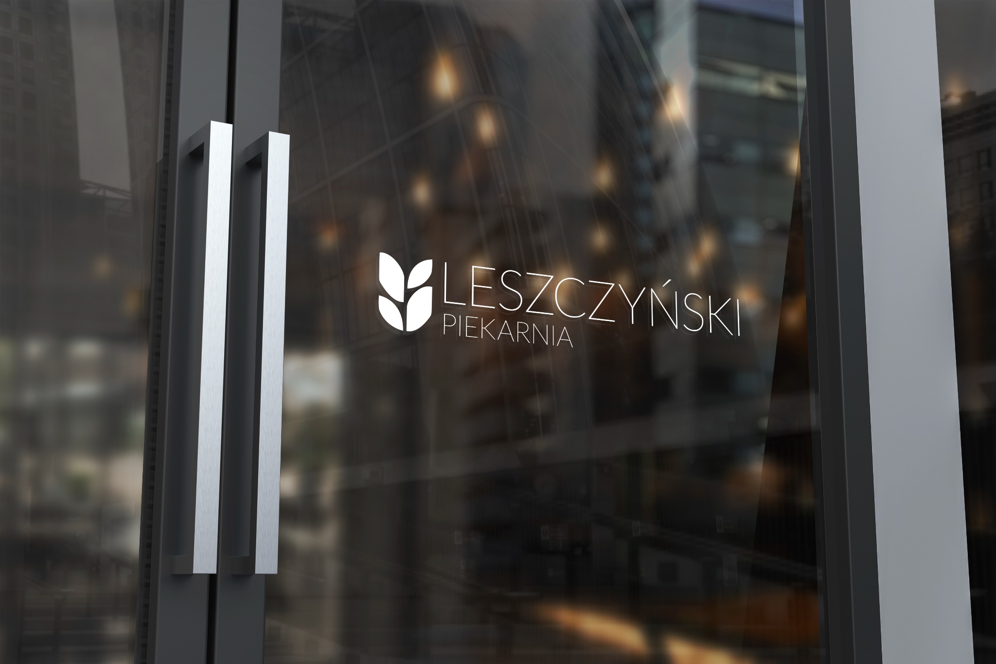 Logo piekarni 'Leszczyński' umieszczone na szklanych drzwiach wejściowych z metalowymi uchwytami, z rozmytym widokiem wnętrza i odbijającymi się budynkami w tle.
