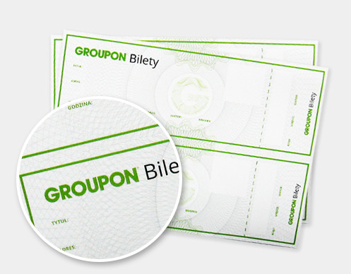Stos biletów Groupon z zielonym nadrukiem, powiększony fragment na pierwszym planie eksponuje detale papieru i tekstu.