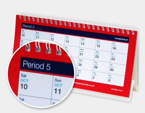 Kalendarz biurkowy z widocznym powiększeniem fragmentu miesiąca października, z czerwonymi elementami i spiralą.