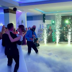 Bella Arte Show - Pierwszy taniec pary młodej w chmurach dymu, z zespołem muzycznym i fontannami iskier w tle, goście klaszczą.