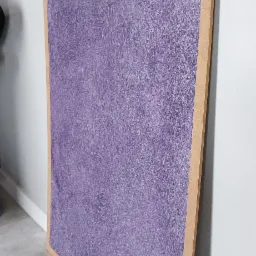 Panel z płyty MDF z dekoracyjną, fioletową strukturą, oparty o ścianę i podłogę.