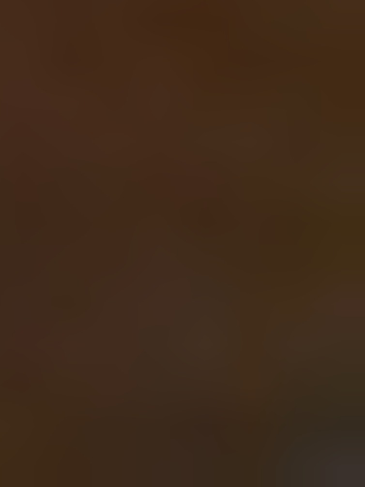 Rozmyte, ciemnobrązowe tło z delikatnymi, nieostrymi przejściami tonalnymi.