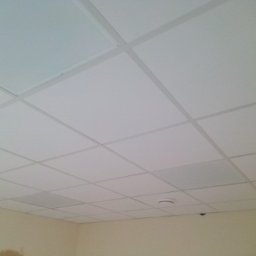 Karpińscy Firma Budowlana - Sufit podwieszany z białych paneli rastrowych w pomieszczeniu w Lisewo, widoczny czujnik dymu.