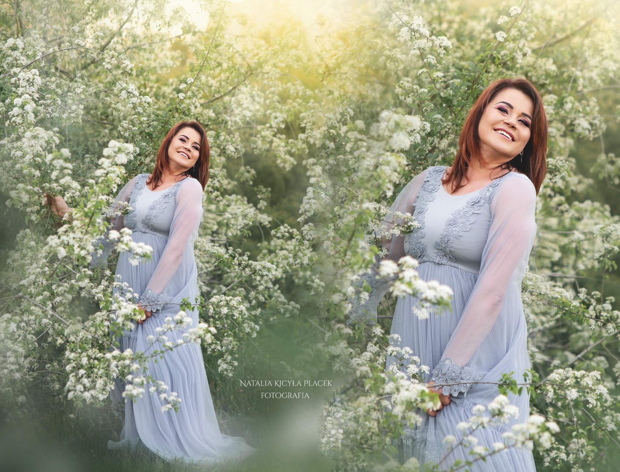 Uśmiechnięta, przyszła mama w zwiewnej, błękitnej sukni z koronkowymi detalami pozuje wśród kwitnących, białych krzewów, z efektem bokeh w tle.
