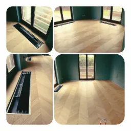 Jasny parkiet ułożony we wzór jodełki francuskiej w nowym pokoju z zielonymi ścianami i zamontowanymi grzejnikami kanałowymi w podłodze.