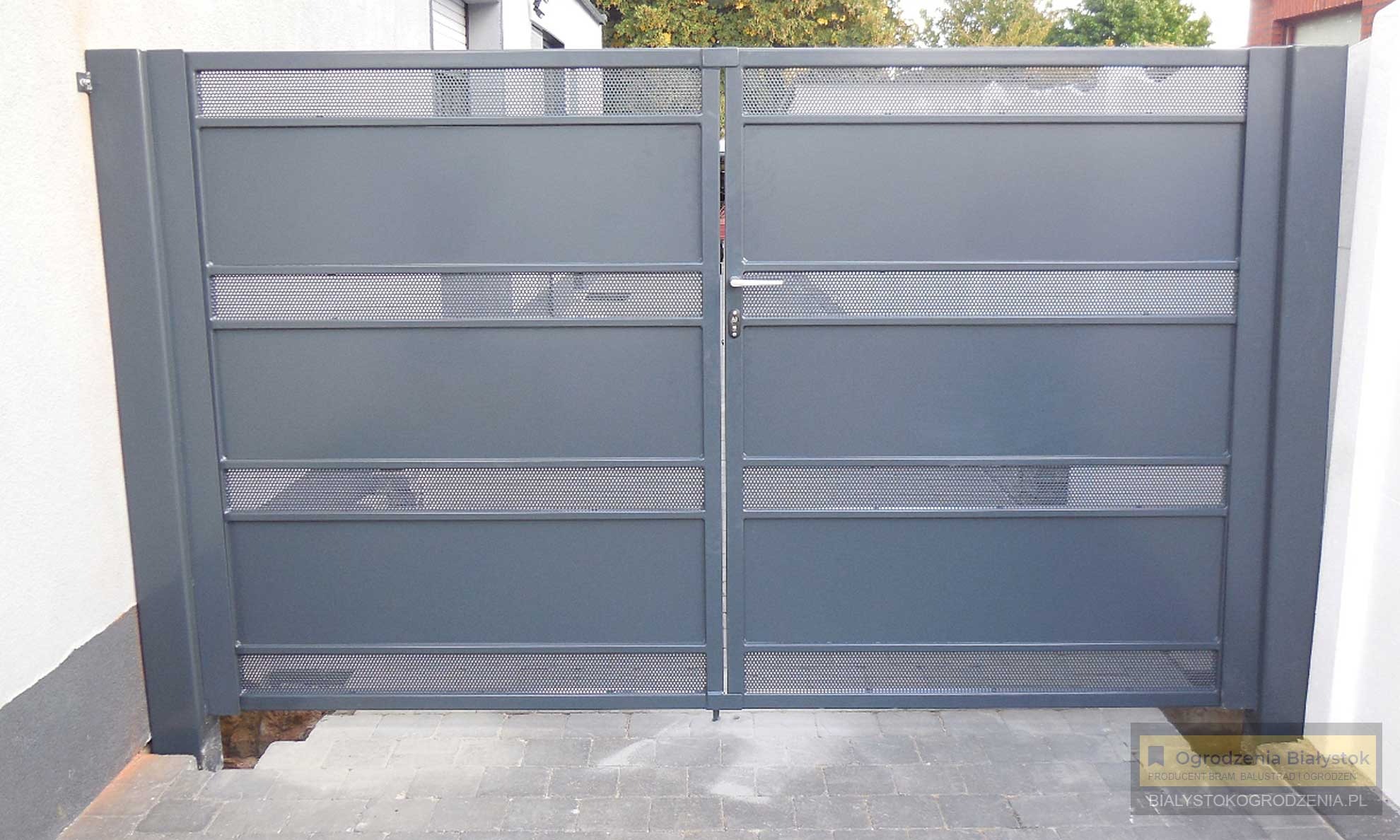 Nowoczesna, dwuskrzydłowa brama wjazdowa z szarego metalu, z poziomymi perforowanymi pasami, widok z zewnątrz na tle kostki brukowej.
