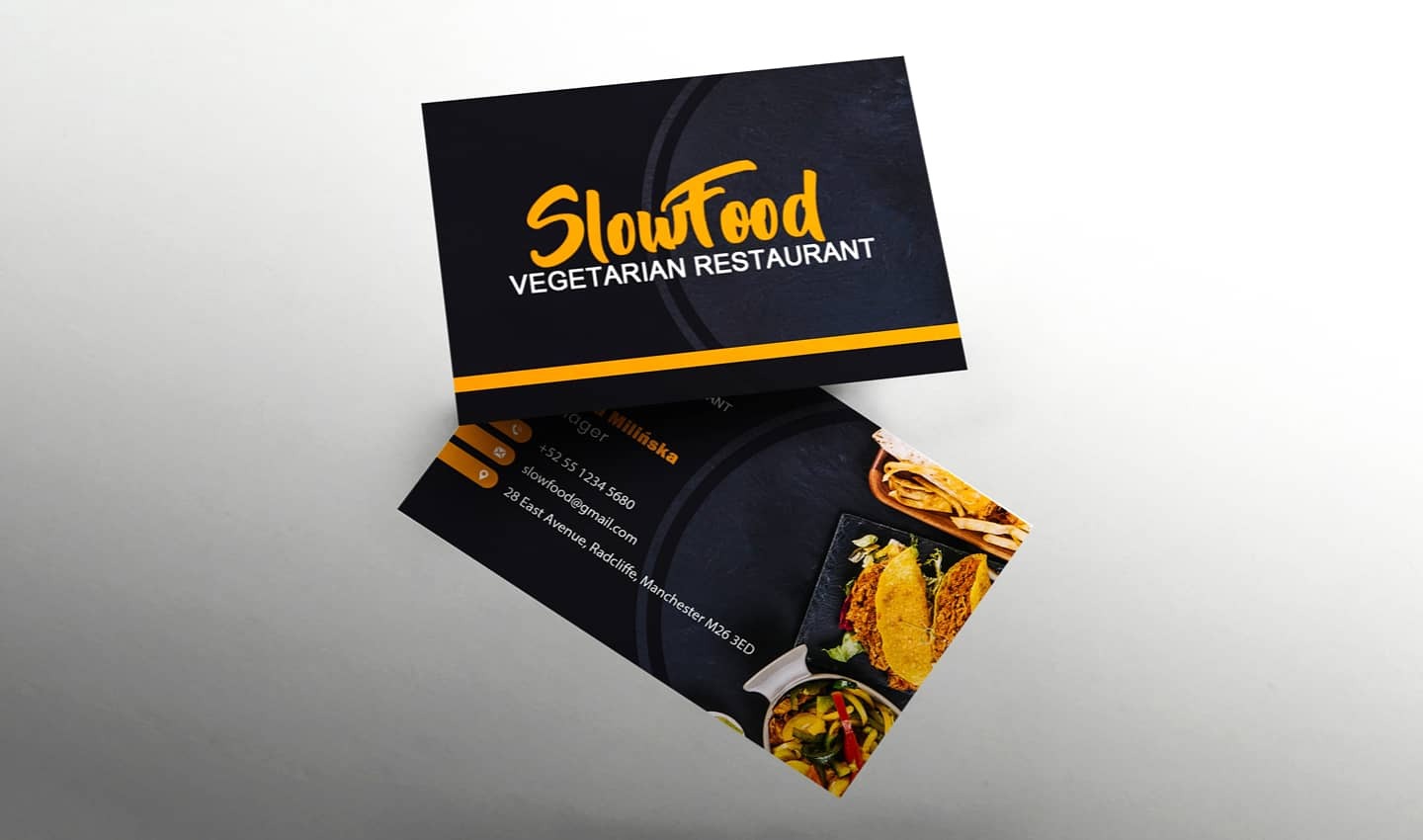 Dwie wizytówki restauracji wegetariańskiej SlowFood, jedna z logo i nazwą, druga z danymi kontaktowymi i zdjęciami potraw, ułożone pod kątem na białym tle.