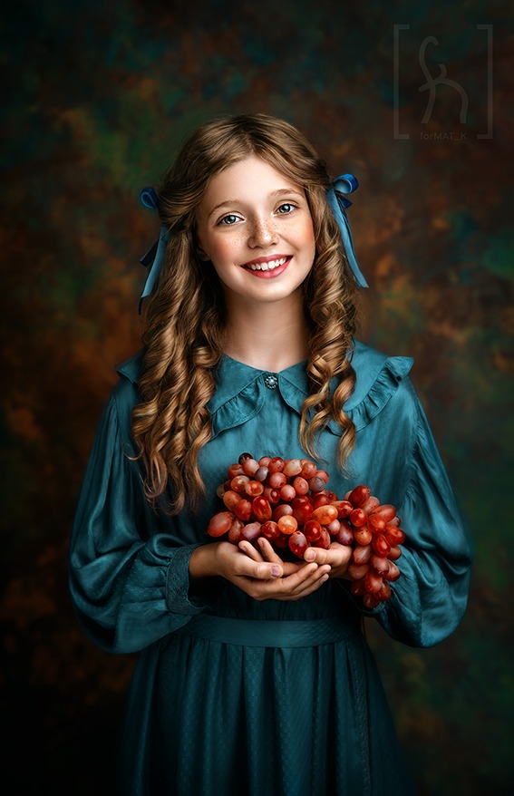 Portret uśmiechniętej dziewczynki z rudymi włosami i niebieskimi kokardami, trzymającej w dłoniach kiść czerwonych winogron na malowanym tle.