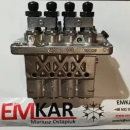 Blok zaworowy z czterema czarnymi pokrętłami, widoczne oznaczenia i ślady montażu, leżący na białym podłożu z częściowo widocznym logo firmy EMKAR.