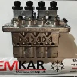 Metalowy blok z czterema zaworami, widoczne oznaczenia i logo firmy EMKAR na wizytówce w tle.