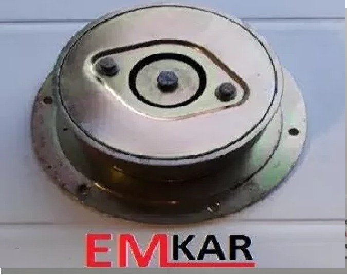 Metalowa obudowa elementu samochodowego z widocznymi śrubami i otworami montażowymi, sfotografowana z bliska na jasnym tle, z widocznym logo EMKAR w dolnej części kadru.