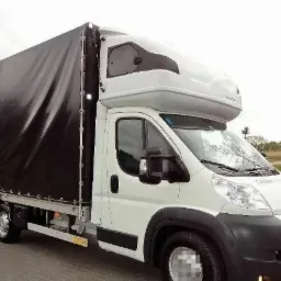 Biały bus z czarną plandeką, specjalistyczny pojazd do transportu, widziany w Sosnowcu.