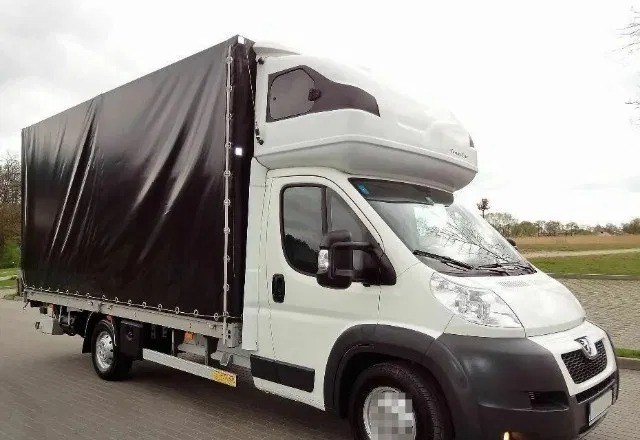 Biały bus z czarną plandeką, specjalistyczny pojazd do transportu, widziany w Sosnowcu.