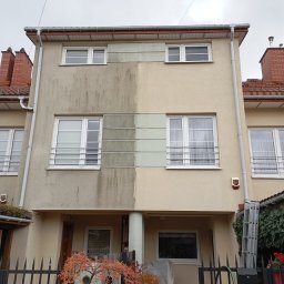 Daniel Dubis - Dwukondygnacyjny dom z elewacją w połowie wyczyszczoną, ukazując różnicę przed i po zabiegu. Widoczne okna z kratami, rynny i fragment dachu z czerwonej dachówki.