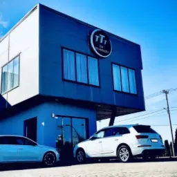 Nowoczesny budynek biurowy w Borowie z logo firmy Top Technology na fasadzie, zaparkowane dwa samochody osobowe.