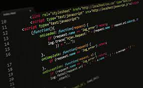 Fragment kodu JavaScript wyświetlony na ekranie komputera z ciemnym motywem, widoczne tagi <script> i <link> oraz definicje funkcji, ukośny kąt ujęcia.