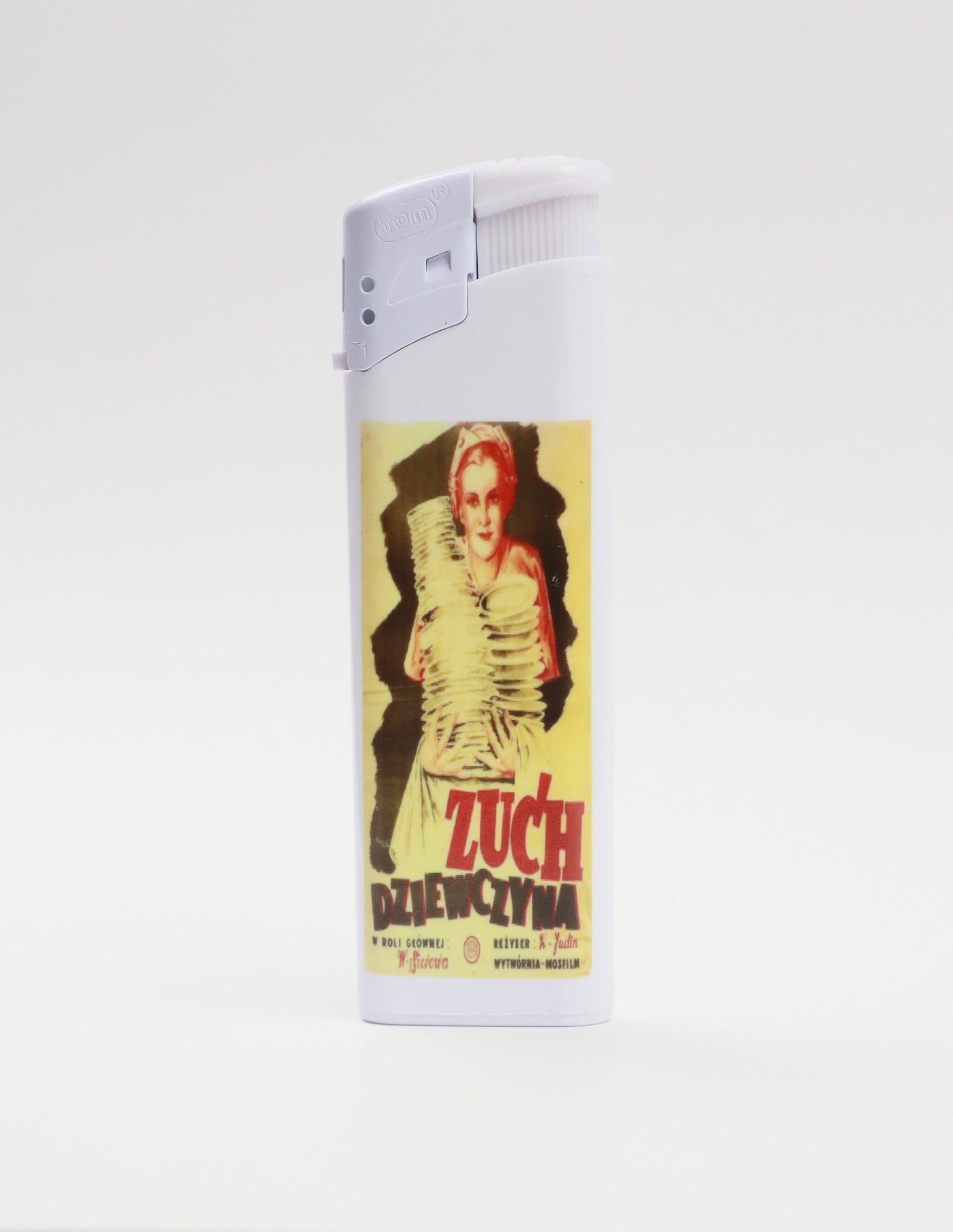 Biała zapalniczka z naklejoną grafiką retro plakatu filmowego 'Zuch Dziewczyna' na białym tle.