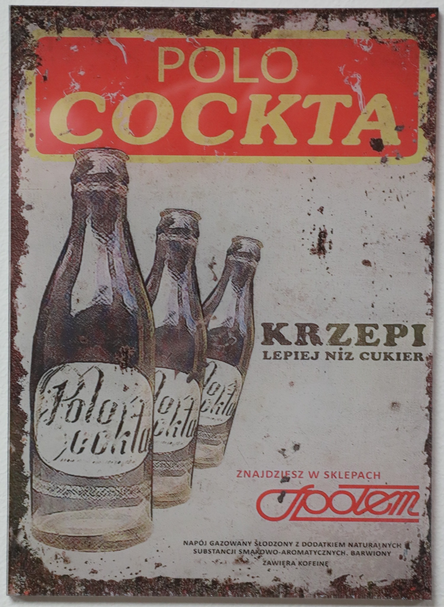 Retro metalowy szyld reklamowy Polo Cockta z trzema butelkami napoju, stylizowany na zardzewiały i zużyty, z widocznymi napisami i logo Społem.