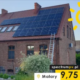 Czerwony dom z cegły z panelami słonecznymi na dachu, drabina oparta o ścianę, częściowo widoczny biały samochód dostawczy.