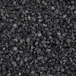 Centrum opałowe K&S - Drobny, czarny węgiel kamienny ułożony równomiernie, widoczne nieregularne kształty bryłek i refleksy światła na ich powierzchni.