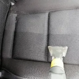 Czyszczenie tapicerki samochodowej parownicą, widoczna r&oacute;żnica w kolorze między czyszczonym a brudnym obszarem.