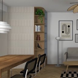 Piotr Krzeminski Pod Klucz - Nowoczesna jadalnia z drewnianym stołem, krzesłami z plecionką i dekoracyjną ścianą z pionowymi panelami. Na ścianie plakat Bauhaus i regał z książkami.