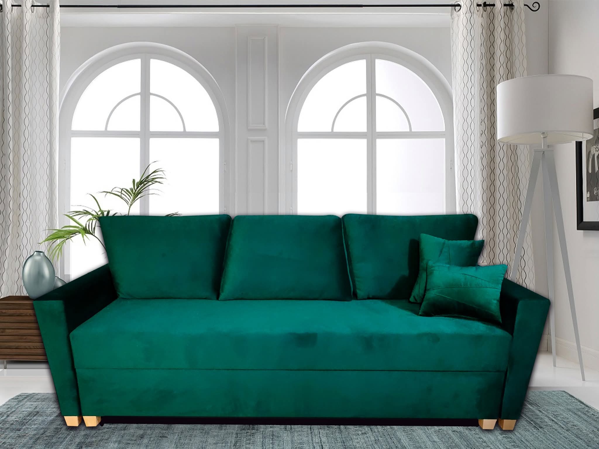 Szmaragdowa sofa z weluru z poduszkami w salonie z oknami łukowymi i lampą na trójnogu. Nowoczesny design, elegancka tapicerka, subtelne oświetlenie.