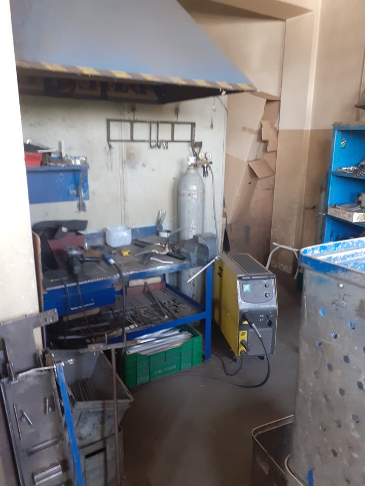 Stanowisko pracy: stół warsztatowy z narzędziami, butla z gazem, pochłaniacz dymu i spawarka inwertorowa w warsztacie.