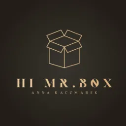 Eleganckie logo firmy 'Hi Mr. Box Anna Kaczmarek' z minimalistyczną grafiką otwartego kartonu w kolorze złota na ciemnobrązowym tle.