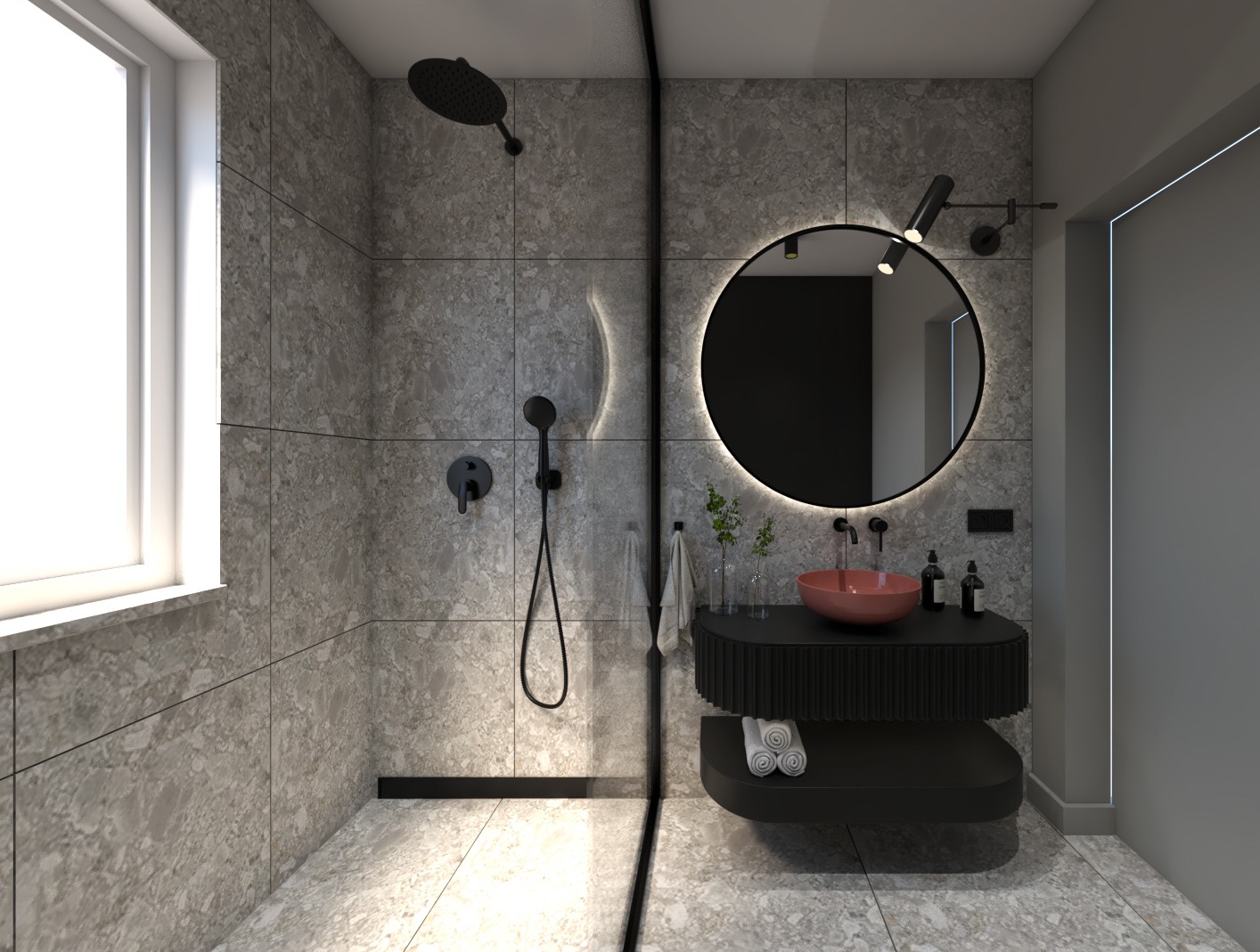 Nowoczesna łazienka z szarymi płytkami imitującymi kamień, okrągłym lustrem z podświetleniem LED, koralową umywalką nablatową i czarną armaturą.