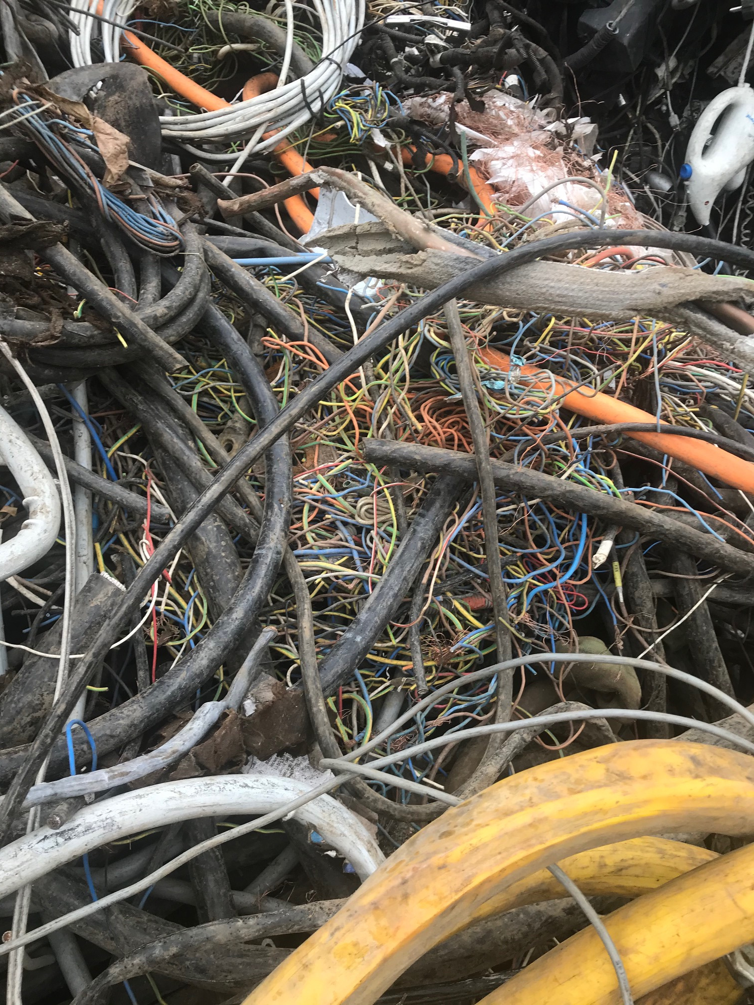 Stos zdemontowanych kabli i przewodów elektrycznych różnej grubości i koloru, prawdopodobnie przeznaczonych do recyklingu, widziany w punkcie skupu złomu w Warszawie.