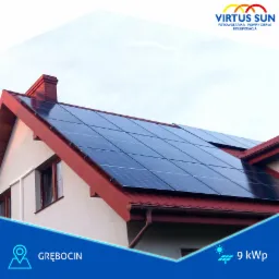 Instalacja paneli słonecznych na dachu domu z czerwoną dachówką, widoczny fragment elewacji i okna. W tle jasne niebo. Logo firmy Virtus Sun w górnym rogu.