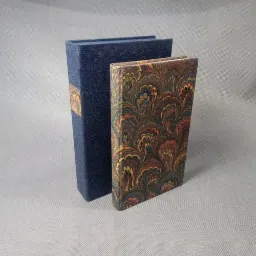 Książka oprawiona w ręcznie marmoryzowany papier oraz pudełko do książki.