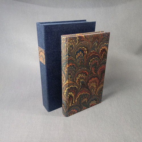 Książka oprawiona w ręcznie marmoryzowany papier oraz pudełko do książki.