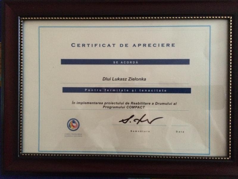 Oprawiony certyfikat uznania w języku rumuńskim dla Lukasz Zielonka za wkład w projekt rehabilitacji drogi w ramach Programu COMPACT.