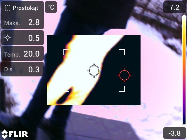 Termowizja fragmentu budynku z naniesionymi danymi pomiarowymi temperatury. Widoczne wartości minimalne i maksymalne temperatury.