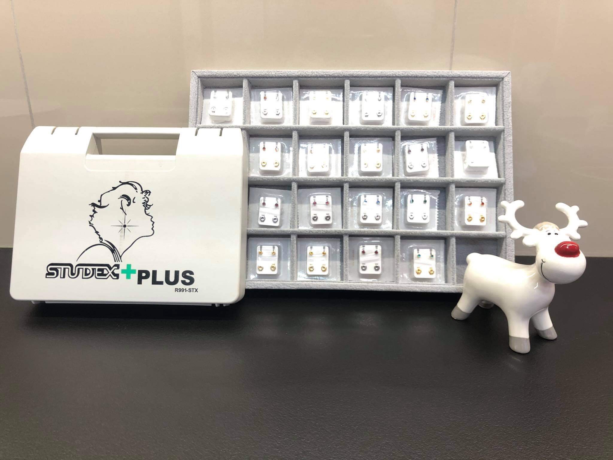 Zestaw do przekłuwania uszu Studex Plus z organizerem kolczyków i dekoracyjną figurką renifera.