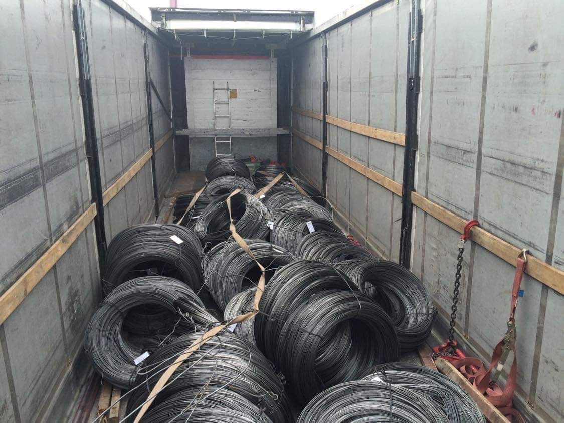 Wnętrze naczepy wypełnionej zwojami drutu stalowego, zabezpieczonymi pasami, widok z Kobierzyc.