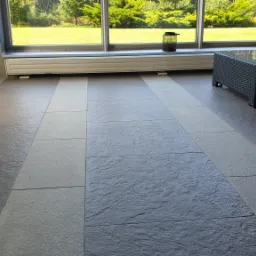 Szare płytki basenowe w Hotelu Natura Residence w Siewierzu, ułożone w pasy, z widocznymi rattanowymi meblami i oknem z widokiem na zieleń.